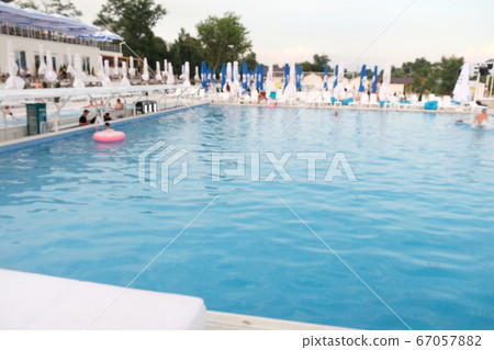 Blurred photo of the pool. Rest and relaxation area. Blurred photo of the pool. Rest and relaxation area. 67057882