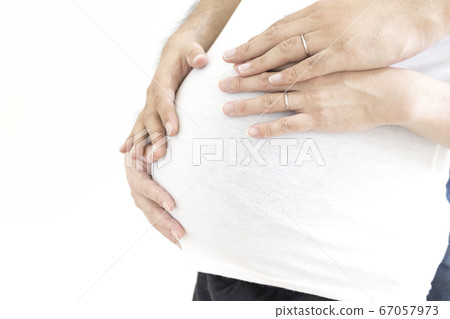 A pregnant woman and her husband touching their stomachs A pregnant woman and her husband touching their stomachs 67057973