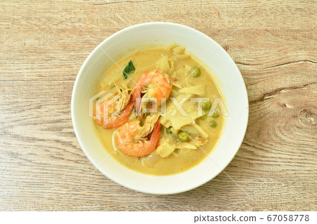 spicy boiled slice pickled bamboo shoot with shrimp and eggplant in coconut milk curry soup on bowl 67058778