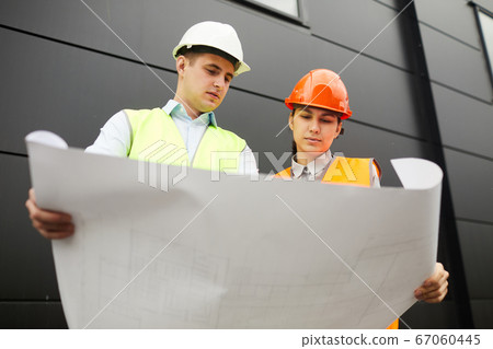 Examining the blueprint of new building 67060445