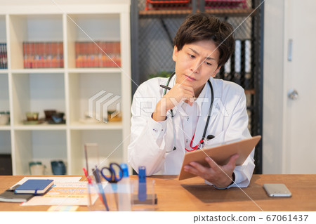 Young male doctor thinking in the examination room 67061437