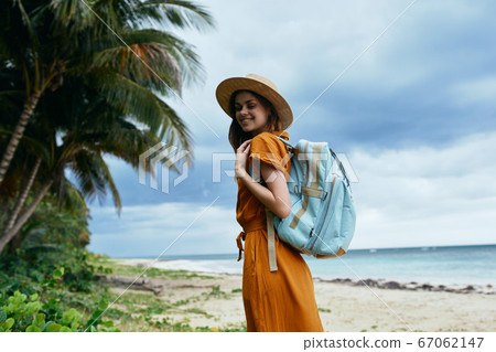 A woman with a backpack on an island near the ocean A woman with a backpack on an island near the ocean 67062147