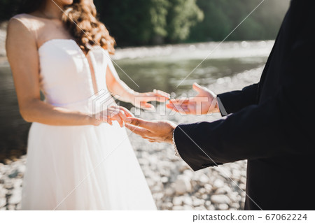 Wedding couple holding hands, groom and bride together on wedding day 67062224
