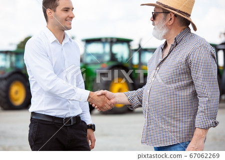 A farmer with a tractor, combine at a field in sunlight. Confident, bright colors A farmer with a tractor, combine at a field in sunlight. Confident, bright colors 67062269