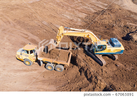 Excavator loading soil onto an Articulated hauler Truck 67063891