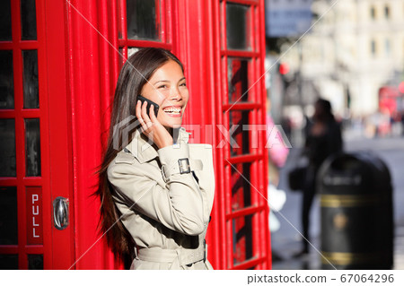 London business woman on smart phone by red booth London business woman on smart phone by red booth 67064296