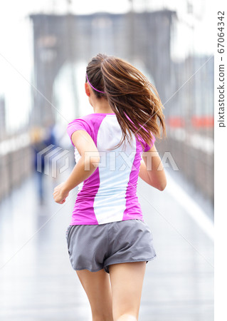 City runner - woman running on Brooklyn Bridge 67064342