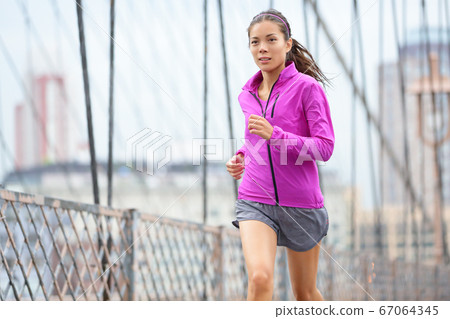Female runner running and jogging in New York City Female runner running and jogging in New York City 67064345