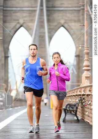Running couple jogging in New York City 67064349