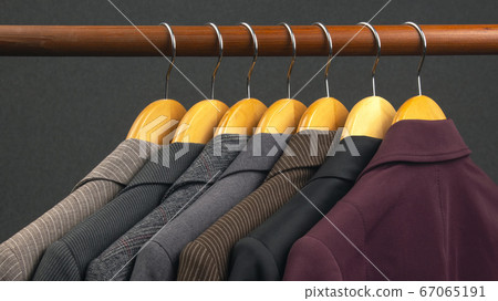Different women's office classic jackets hang on a hanger for storing clothes. The choice of style of fashionable clothes. Different women's office classic jackets hang on a hanger for storing clothes. The choice of style of fashionable clothes. 67065191