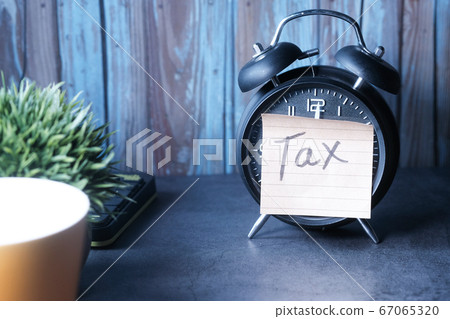 Tax Text on Adhesive Note on Alarm Clock. Tax Text on Adhesive Note on Alarm Clock. 67065320