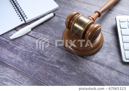 Top view of gavel, notepad and keyboard on table  67065323