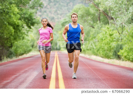Running young couple outside jogging happy smiling Running young couple outside jogging happy smiling 67066290