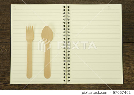 Notebook, fork and spoon on the table 67067461