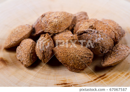 Unpeeled salted almonds closeup on a wooden table. Nuts. Healthly food. Unpeeled salted almonds closeup on a wooden table. Nuts. Healthly food. 67067587