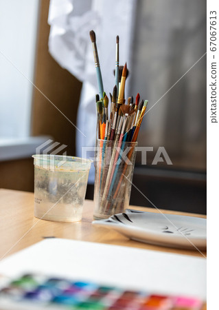 Art brushes for painting in a glass cup on the desktop. 67067613
