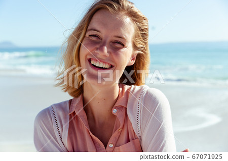 Portrait of woman smiling on the beach Portrait of woman smiling on the beach 67071925