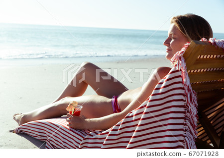 Woman enjoying cocktail at the beach Woman enjoying cocktail at the beach 67071928