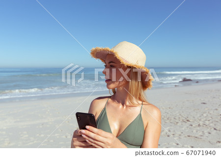 Woman using smartphone on the beach Woman using smartphone on the beach 67071940