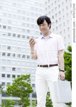 Businessman looking at a smartphone Businessman looking at a smartphone 67072244