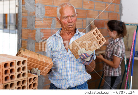 Man with daughter working with red brick Man with daughter working with red brick 67073124