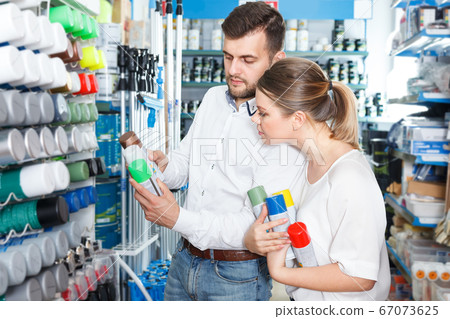 Couple choosing paint spray in shop Couple choosing paint spray in shop 67073625