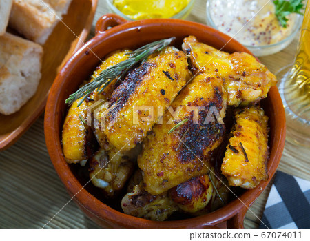 Roasted chicken wings in clay bowl Roasted chicken wings in clay bowl 67074011