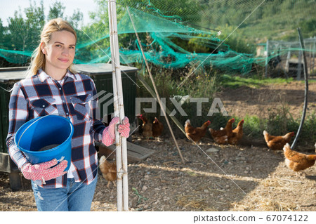 Female farmer on poultry yard 67074122