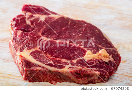 Fresh chop of beef on natural wooden background, nobody Fresh chop of beef on natural wooden background, nobody 67074298