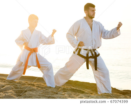 Teacher and boy doing karate poses 67074399
