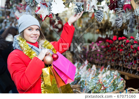 Young female near counter with xmas gifts on street market Young female near counter with xmas gifts on street market 67075160