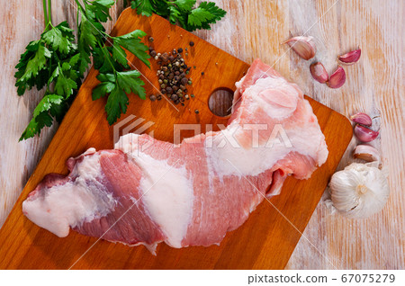 Preparation of raw pork cinch parsley and garlic on cutting board Preparation of raw pork cinch parsley and garlic on cutting board 67075279