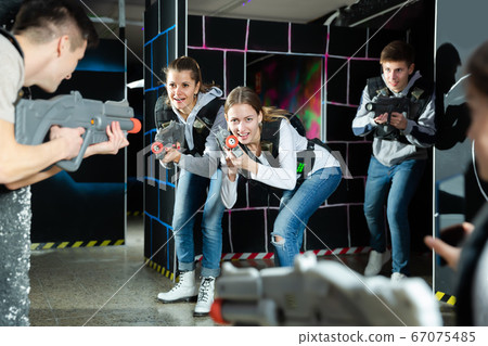Young women having fun on dark lasertag arena Young women having fun on dark lasertag arena 67075485