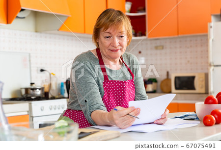 Thoughtful woman with paper documents 67075491