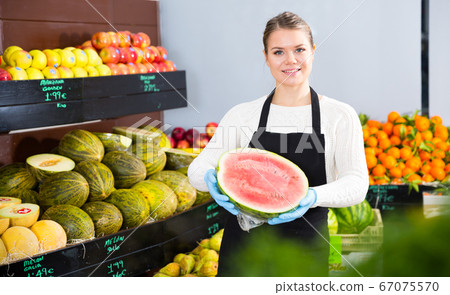 Woman offering watermelon and other fresh fruits on the market Woman offering watermelon and other fresh fruits on the market 67075570