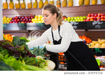 Salesgirl arranging greens Salesgirl arranging greens 67075710