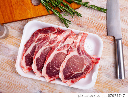 Close up of raw pork's chops on wooden table 67075747