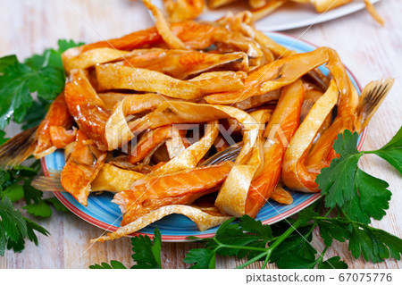Smoked salmon belly strips on plate on wooden table Smoked salmon belly strips on plate on wooden table 67075776