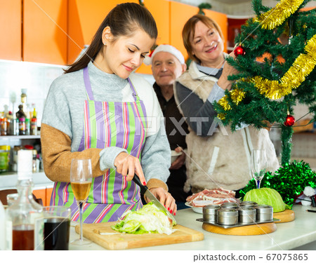 Woman cooking food for christmas dinner at home with parents 67075865