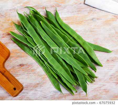 Fresh green beans on wooden surface in home kitchen Fresh green beans on wooden surface in home kitchen 67075932