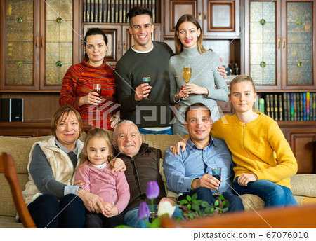 Happy large family gathered in parental home Happy large family gathered in parental home 67076010