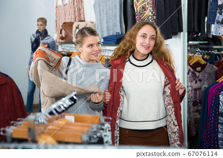 Woman trying new overcoat 67076114