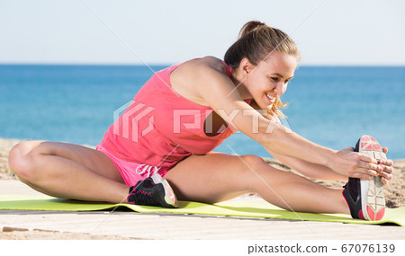 Young sporty woman exercising Young sporty woman exercising 67076139