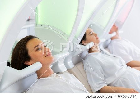Clients of beauty salon relaxing on massaging chairs Clients of beauty salon relaxing on massaging chairs 67076384