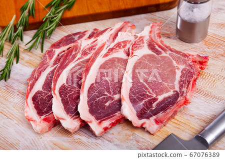 Raw pork chops on rib with herbs Raw pork chops on rib with herbs 67076389