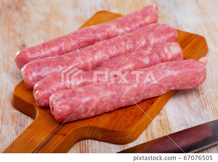 Raw sausages for frying on wooden surface Raw sausages for frying on wooden surface 67076505