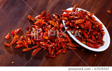 Dried cayenne pepper on white plate Dried cayenne pepper on white plate 67076507