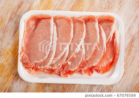 Sliced raw pork tenderloin on plastic tray Sliced raw pork tenderloin on plastic tray 67076589