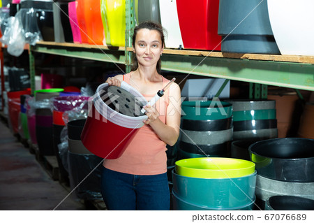 Florist demonstrating big plastic flowerpots 67076689