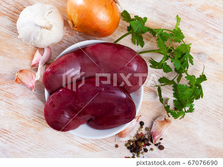 Raw pork kidney with garlic and greens before cooking Raw pork kidney with garlic and greens before cooking 67076690
